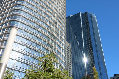 Low angle view of modern buildings against clear blue sky