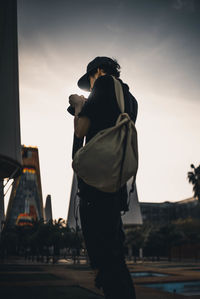 Side view of man standing against sky during sunset