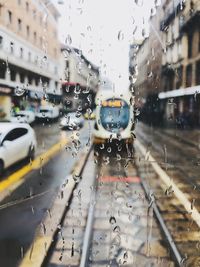 Vehicles seen through wet window on city street