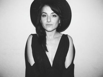 Portrait of young woman standing against white background