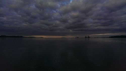 Scenic view of calm sea against cloudy sky