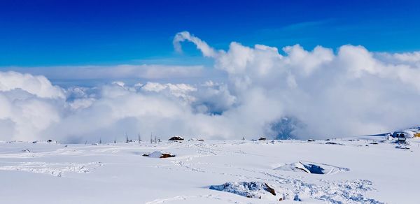 Panoramic view of snow covered landscape against sky