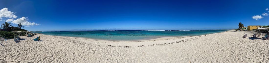 Scenic view of beach against blue sky