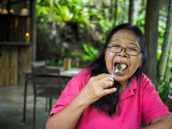 Portrait of the happy grandma enjoying her snack