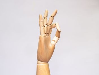 Close-up of wooden hand against white background