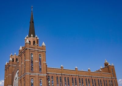 Low angle view of clock tower against blue sky