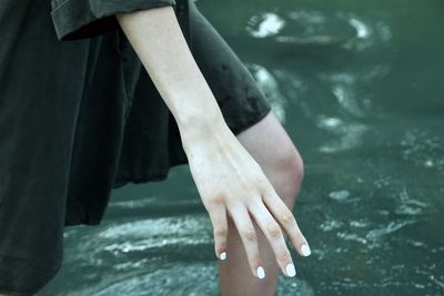 Midsection of woman walking in lake