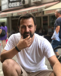 Portrait of young man sitting outdoors