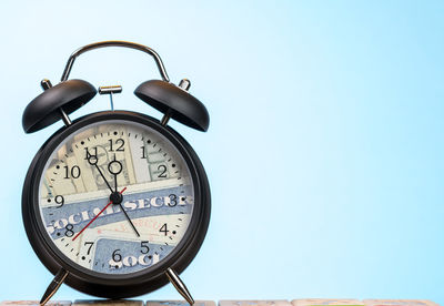 Low angle view of clock against blue sky