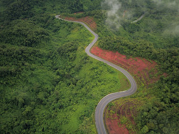 Countryside road passing through the lush green tropical rain forest mountain landscape