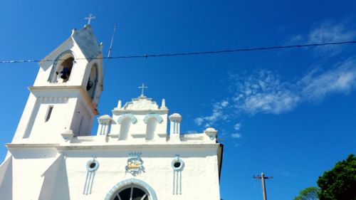 Low angle view of bell tower against blue sky