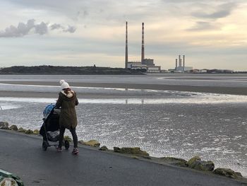 Woman on shore against sky during winter