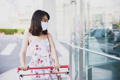 Young woman looking away while standing in bus