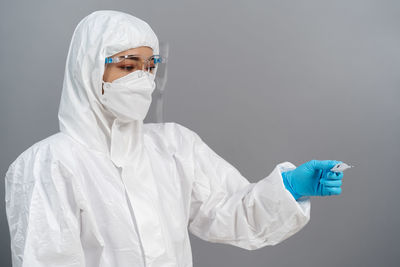 Portrait of woman wearing surgical mask against white background