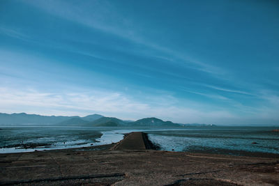 Scenic view of beach against blue sky