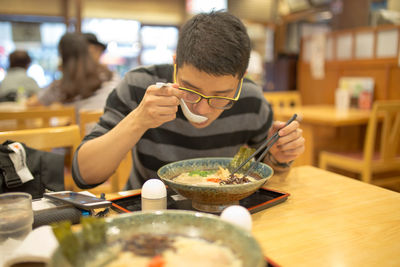 Midsection of man having food in restaurant
