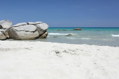 Rocks on beach against clear sky