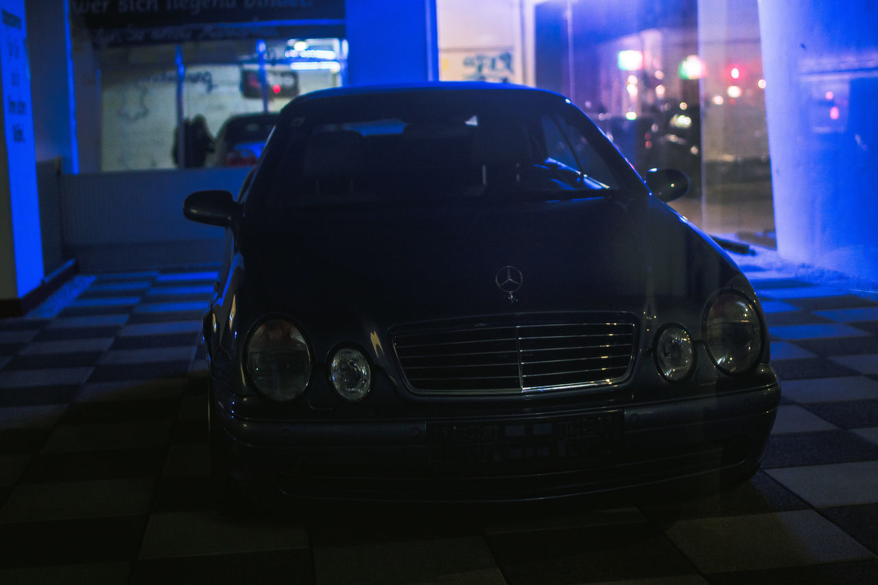 CLOSE-UP OF CAR ON ILLUMINATED STREET