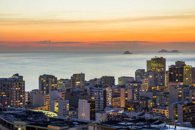 Aerial view of city lit up at sunset