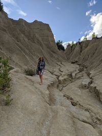 Woman walking on mountain against sky