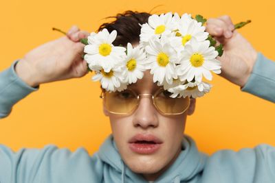 Portrait of young man with flower on face