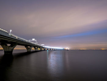 Bridge over sea against sky during sunset