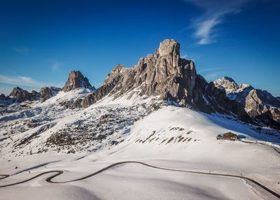 Scenic view of snowcapped mountains against blue sky