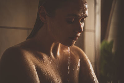 Portrait of shirtless young woman in bathroom
