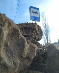 Low angle view of text on rock against sky