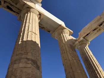 Low angle view of old ruins against blue sky