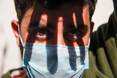Portrait of man wearing face mask with shadows