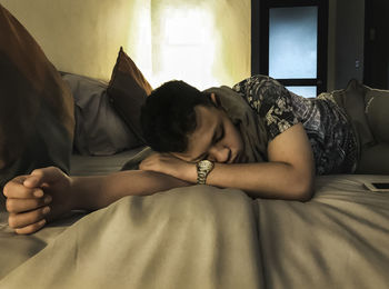 Woman lying on bed at home