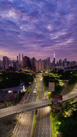 High angle view of illuminated street amidst buildings in city