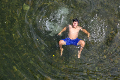 High angle view of shirtless man in water