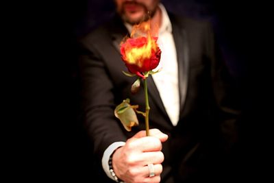 Close-up of woman hand holding red flower