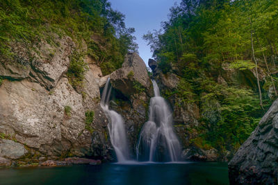 Scenic view of waterfall against sky