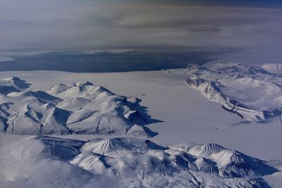Aerial view of snowcapped mountains against sky