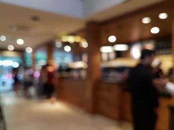 Defocused image of people at illuminated railroad station