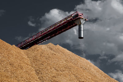 Low angle view of crane against sky