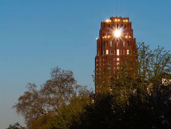 Low angle view of illuminated building against clear sky at night