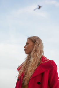 Portrait of woman standing against sky