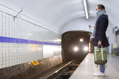 Full length of man standing at subway station