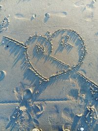 Close-up of footprints on sand at beach