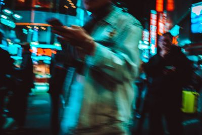 Blurred motion of people on illuminated city at night