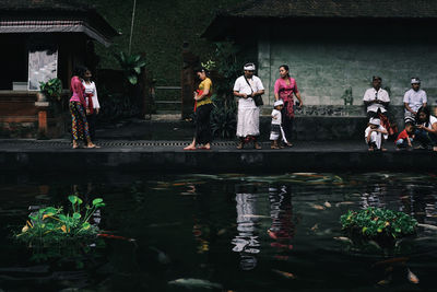 Group of people in pond by building