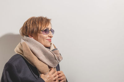 Young woman wearing sunglasses against white background