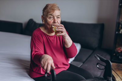 Portrait of young woman sitting on sofa at home