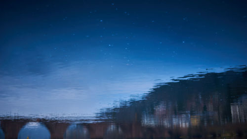 Scenic view of lake against sky at night