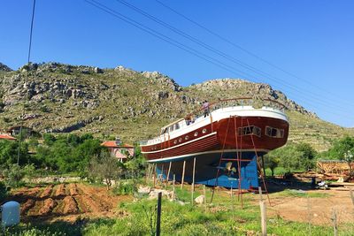 Built structure on landscape against clear blue sky