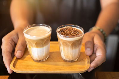 Midsection of woman holding coffee on table